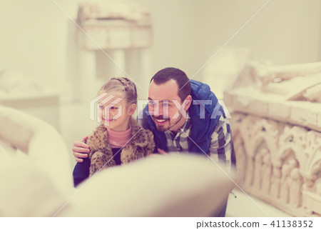 friendly father and daughter regarding classical bas-reliefs in museum 41138352