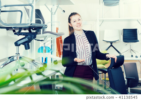 Saleswoman welcoming to chair store 41138545