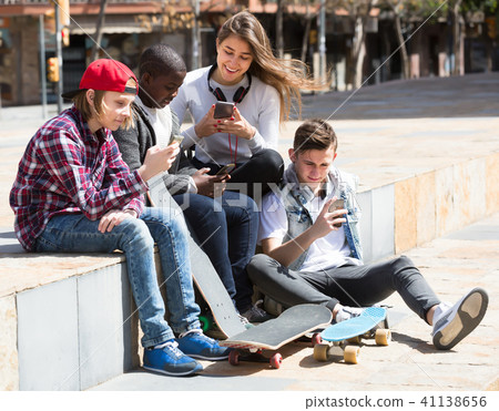 Laughing friends with smartphones in spring day Laughing friends with smartphones in spring day 41138656