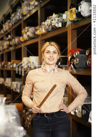 Female seller of fabric shop showing textiles 41138882