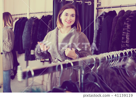 Female customer examining new sheepskin coat 41139119