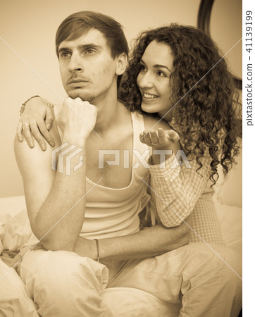 Smiling girl trying to comfort upset husband 41139199