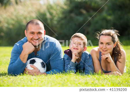 family lying in the grass. 41139200