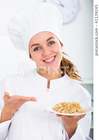Girl cook shows plate of porrige Girl cook shows plate of porrige 41139245