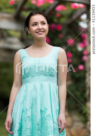portrait of young woman in dress near roses in a garden portrait of young woman in dress near roses in a garden 41139455