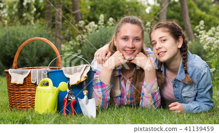 smiling young woman and girl with gardening tools in outdoors smiling young woman and girl with gardening tools in outdoors 41139459
