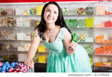 Happy girl with lollipop at candies shop Happy girl with lollipop at candies shop 41139595