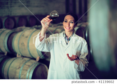 woman with glass of wine in cellar. 41139602