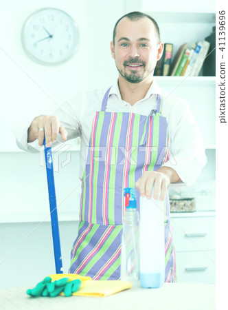 Young man in apron cleaning table Young man in apron cleaning table 41139696