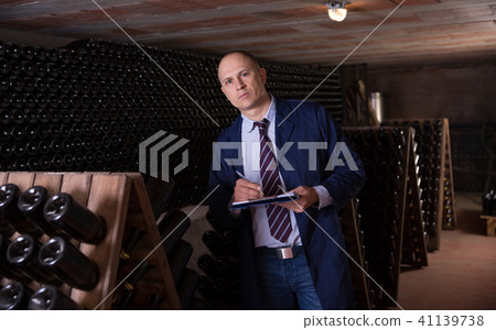 Wine producer with clipboard in wine cellar Wine producer with clipboard in wine cellar 41139738