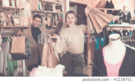 Smiling couple is satisfied of purchases and standing with packa 41139751