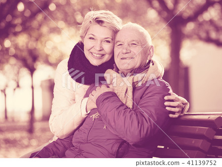 Mature couple sitting in park Mature couple sitting in park 41139752