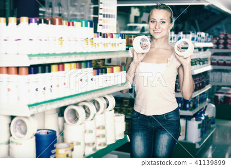 Positive woman customer choosing adhesive tape in household store Positive woman customer choosing adhesive tape in household store 41139899