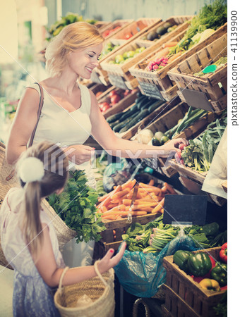 Glad mother with daughter shopping various veggies Glad mother with daughter shopping various veggies 41139900