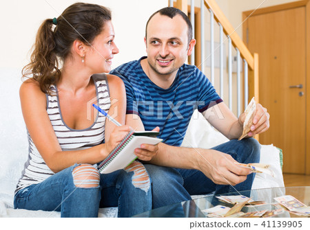 woman watching her husband counting money 41139905