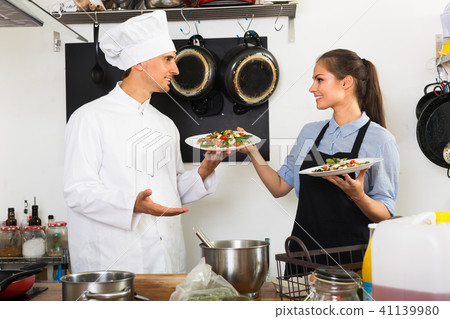 cook and waitress at cafe’s kitchen. cook and waitress at cafe’s kitchen. 41139980