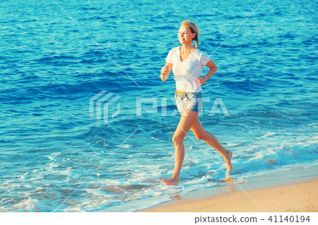 Sportswoman is jogging on the beach Sportswoman is jogging on the beach 41140194