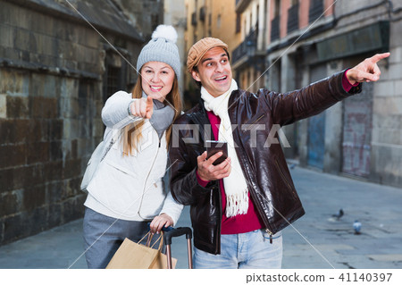 tourists in hats and scarfs pointing finger 41140397