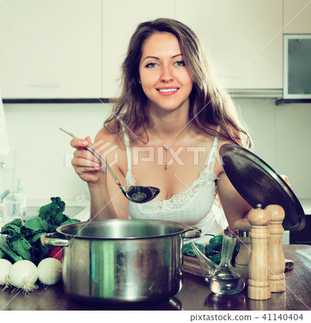 Woman cooking soup in kitchen Woman cooking soup in kitchen 41140404