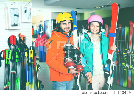 Man and woman standing with purchased ski equipment in shop Man and woman standing with purchased ski equipment in shop 41140409