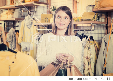 Woman carrying paper bags with purchases in fashion store Woman carrying paper bags with purchases in fashion store 41140411