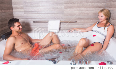 Man with woman are relaxing in jacuzzi with petals of roses Man with woman are relaxing in jacuzzi with petals of roses 41140499