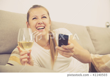 Girl is resting with wine and watching TV Girl is resting with wine and watching TV 41140503