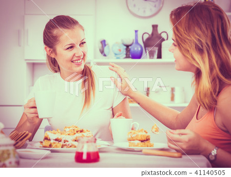 Two young female are drinking tea and talking about life Two young female are drinking tea and talking about life 41140505