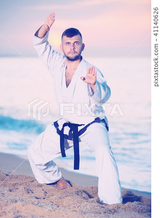 Ordinary male doing karate at ocean quay Ordinary male doing karate at ocean quay 41140626