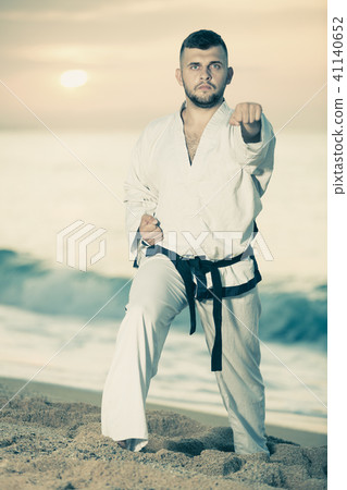 Active male doing karate at ocean quay Active male doing karate at ocean quay 41140652