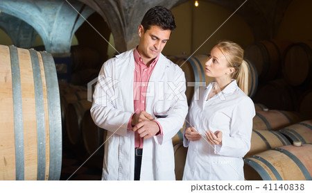 Two speaking wine house workers checking quality of product Two speaking wine house workers checking quality of product 41140838