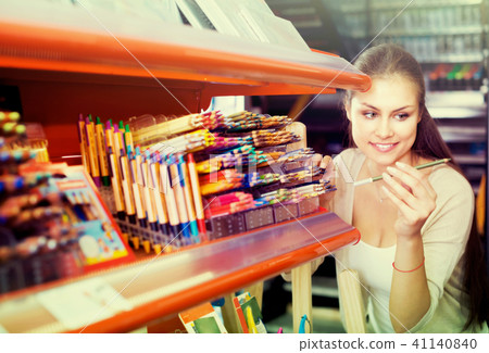 female customer picking pencils in art store. 41140840