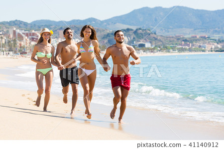 Adults running at sandy beach 41140912