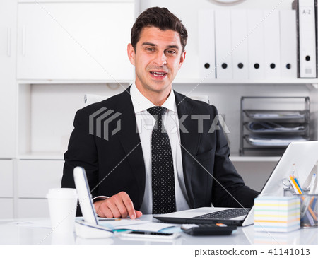 Respectable and cheerful businessman in office 41141013