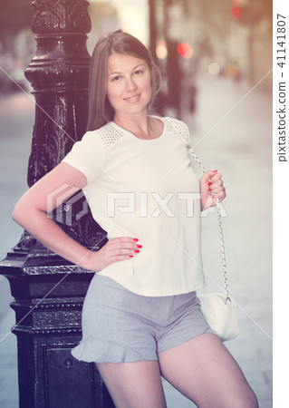 Girl leaning old lamp post on street 41141807