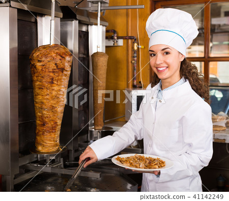 Female chef cutting meat for shawarma . 41142249