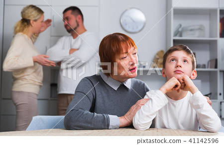 Grandma hugging upset boy during parental quarrel Grandma hugging upset boy during parental quarrel 41142596