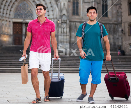 Men tourists walking with suitcases Men tourists walking with suitcases 41142631