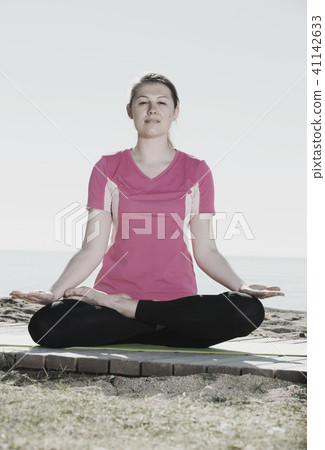 Woman training yoga poses on beach Woman training yoga poses on beach 41142633