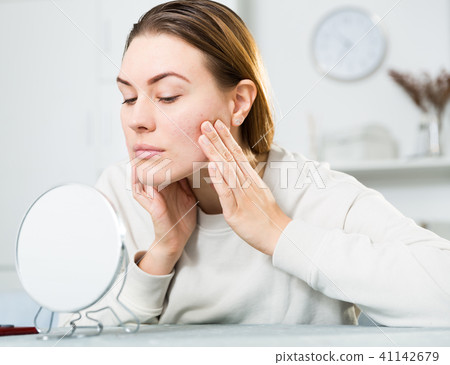 Young woman is satisfied of quality her skin in with mirror 41142679