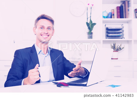 Young business man holding cup with coffee Young business man holding cup with coffee 41142983