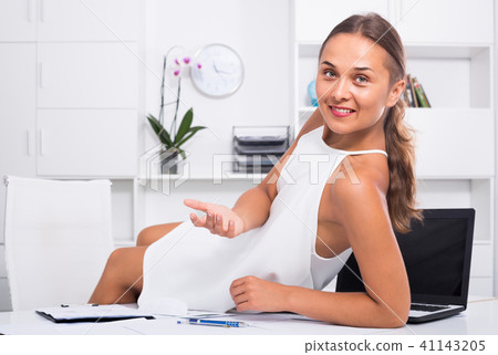 portrait of woman in dress resting on table in office portrait of woman in dress resting on table in office 41143205