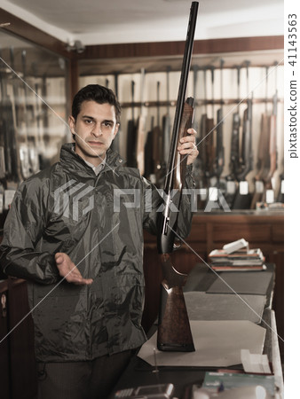 Portrait of glad confident man showing rifle Portrait of glad confident man showing rifle 41143563