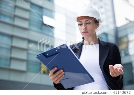 Woman architector in suit and hat is dissatisfieded of documents with project Woman architector in suit and hat is dissatisfieded of documents with project 41143672