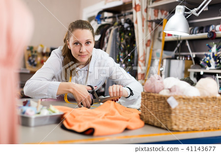Smiling woman professional working with material at atelier 41143677