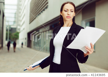 Serious woman is dissatisfied of the results of the financial report Serious woman is dissatisfied of the results of the financial report 41143695