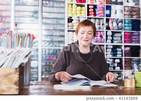 Woman sits at desc in shop 41143809
