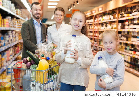 family is standing with trolley with food family is standing with trolley with food 41144016