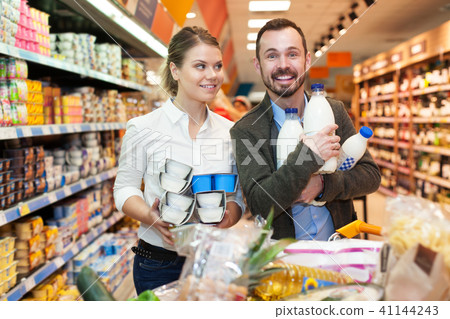 Couple buying milk in supermarket Couple buying milk in supermarket 41144243