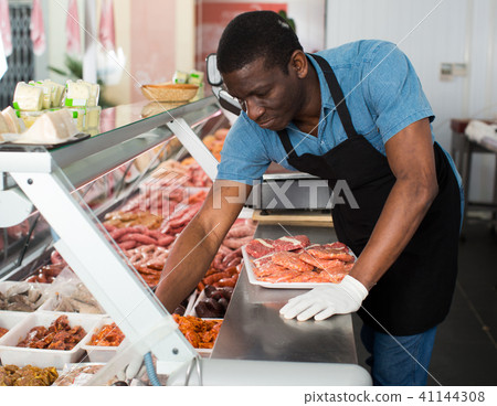 Butcher arranging meat display Butcher arranging meat display 41144308